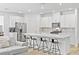 Modern kitchen boasts stainless appliances, white cabinets and a large island with bar stool seating at 10165 Canyon Mantle St, Las Vegas, NV 89166