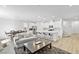 Open living space with modern kitchen, stainless appliances, white cabinets and island with seating at 10165 Canyon Mantle St, Las Vegas, NV 89166