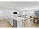 Open-concept living space with a kitchen island, dining area, and comfortable seating by bright windows at 10165 Canyon Mantle St, Las Vegas, NV 89166