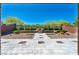 Extensive paved backyard, well manicured landscaping with brick walls, stone features, and mature shade trees at 10348 Bressana Dr, Las Vegas, NV 89135