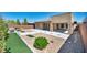 Landscaped backyard with decorative rock, artificial turf, and a covered patio area perfect for entertaining at 10348 Bressana Dr, Las Vegas, NV 89135