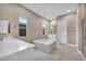 Bright bathroom features tile flooring, dual sinks, shower, and a soaking tub at 10348 Bressana Dr, Las Vegas, NV 89135