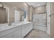 Bright bathroom featuring a white double vanity, tiled floors, and a shower-tub combination at 10348 Bressana Dr, Las Vegas, NV 89135