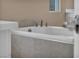 Elegant bathroom boasting a white soaking tub with tile surround and silver faucet and handles at 10348 Bressana Dr, Las Vegas, NV 89135