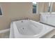 Elegant bathroom boasting a white soaking tub with tile surround and a double sink vanity at 10348 Bressana Dr, Las Vegas, NV 89135