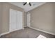 Neutral bedroom with double closet, ceiling fan, and interior door to the bathroom at 10348 Bressana Dr, Las Vegas, NV 89135