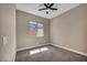 Neutral bedroom featuring a window and ceiling fan with carpet flooring at 10348 Bressana Dr, Las Vegas, NV 89135