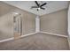 A spacious bedroom, featuring neutral paint, ceiling fan, carpet and access to an ensuite bathroom at 10348 Bressana Dr, Las Vegas, NV 89135