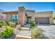 Modern single-story home with a stone accent wall and a well-manicured front yard at 10348 Bressana Dr, Las Vegas, NV 89135