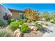 Landscaped yard featuring drought-resistant plants, gravel beds, and a paved driveway at 10348 Bressana Dr, Las Vegas, NV 89135