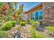 Well-maintained front yard with decorative rock, shrubs, and a vibrant flowering tree near the home's entryway at 10348 Bressana Dr, Las Vegas, NV 89135