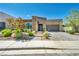 Charming single-story home featuring manicured landscaping, a stone facade, and a paved driveway at 10348 Bressana Dr, Las Vegas, NV 89135