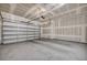 Spacious unfinished garage featuring smooth concrete floor and a large insulated door at 10348 Bressana Dr, Las Vegas, NV 89135
