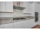 Close up on the granite counters, backsplash, range, and hood at 10348 Bressana Dr, Las Vegas, NV 89135