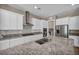 Gourmet kitchen features stainless steel appliances, double ovens, a granite island, white cabinets, and tile backsplash at 10348 Bressana Dr, Las Vegas, NV 89135
