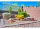 Detailed landscape design featuring decorative rock, brick edging, and a variety of plants and shrubs at 10348 Bressana Dr, Las Vegas, NV 89135