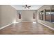 Spacious living room featuring wood floors, neutral walls, ceiling fan, and natural light at 10348 Bressana Dr, Las Vegas, NV 89135