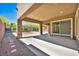 Covered patio with stone columns offers a view of the landscaped backyard, perfect for outdoor relaxation at 10348 Bressana Dr, Las Vegas, NV 89135