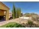 Backyard area with artificial turf, spa, brick patio, barbecue, and desert landscaping at 1074 Wagon Trl, Mesquite, NV 89034