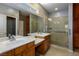 Bright bathroom features double sinks, custom cabinets, walk in shower, and a skylight at 1074 Wagon Trl, Mesquite, NV 89034