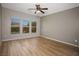 Spacious bedroom featuring three windows with a ceiling fan and wood look flooring at 1074 Wagon Trl, Mesquite, NV 89034