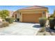 Home exterior showing a two-car garage, desert landscaping, and a paved driveway at 1074 Wagon Trl, Mesquite, NV 89034