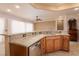 Granite countertops and wood cabinets surround a kitchen island with sink in a neutral color palette at 1074 Wagon Trl, Mesquite, NV 89034