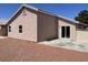 Backyard with gravel and a patio, showing the back of the house with window and door at 1907 Thunder Storm Ave, North Las Vegas, NV 89032