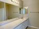 This bathroom features neutral walls, tile flooring, and a large mirror over the sink and vanity at 1907 Thunder Storm Ave, North Las Vegas, NV 89032