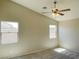 This bedroom features neutral walls, carpet flooring, windows, and a ceiling fan with light fixture at 1907 Thunder Storm Ave, North Las Vegas, NV 89032