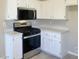 Modern kitchen with stainless steel appliances, white cabinetry, and ample counter space at 1907 Thunder Storm Ave, North Las Vegas, NV 89032