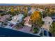 A sun-kissed aerial view of a single-Gathering home shows the roof, driveway, and mature trees in this residential area at 2104 Inverness Dr, Henderson, NV 89074
