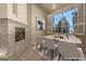 Bright dining room with a modern table, fireplace, and large window with shutters at 2104 Inverness Dr, Henderson, NV 89074