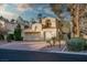 Charming two-story home featuring a three-car garage, lush landscaping, and brick driveway at 2104 Inverness Dr, Henderson, NV 89074