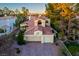 Aerial view of a two-story home with a well-manicured lawn and three-car garage at 2104 Inverness Dr, Henderson, NV 89074