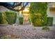 Landscaped front yard with mature trees and plants, a brick pathway, and a gated entrance at 2104 Inverness Dr, Henderson, NV 89074
