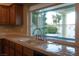 Kitchen sink features a bright window overlooking the outdoor pool at 2104 Inverness Dr, Henderson, NV 89074