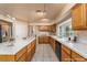 Well-lit kitchen with oak cabinets, stainless steel refrigerator, and white tile countertops at 2104 Inverness Dr, Henderson, NV 89074