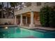 Backyard pool and patio of a two-story home with manicured desert landscaping at 2104 Inverness Dr, Henderson, NV 89074