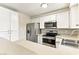 A kitchen featuring stainless steel appliances, white cabinets, and a breakfast bar for casual dining at 2232 Aspen Mirror Way # 103, Laughlin, NV 89029