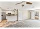 Open-concept living room with tile entry and carpet flooring next to the white cabinet kitchen area at 2232 Aspen Mirror Way # 103, Laughlin, NV 89029