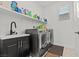 Organized laundry room featuring modern washer and dryer, sink, and ample storage space at 2243 Albury Ave, North Las Vegas, NV 89086