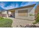 Backyard with covered patio, desert landscaping, retaining wall, and bushes at 2409 Garganey Ave, North Las Vegas, NV 89084