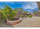 Backyard with low-maintenance gravel landscaping, trimmed bushes, and brick retaining wall at 2409 Garganey Ave, North Las Vegas, NV 89084