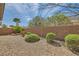 Backyard featuring low-maintenance landscaping, brick wall, green bushes, and blue skies at 2409 Garganey Ave, North Las Vegas, NV 89084