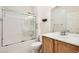 Bathroom features shower-over-tub with glass enclosure and modern vanity with white countertop at 2409 Garganey Ave, North Las Vegas, NV 89084
