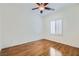 A clean, spacious bedroom features wood flooring, white shutters, and a ceiling fan at 2409 Garganey Ave, North Las Vegas, NV 89084