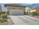 Attached garage with brick-lined driveway and desert landscaping; located in a quiet neighborhood at 2409 Garganey Ave, North Las Vegas, NV 89084