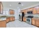 Bright kitchen with wood cabinets, stainless steel appliances, and tile floors offers a modern cooking experience at 2409 Garganey Ave, North Las Vegas, NV 89084