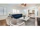 Living room boasts natural light from shuttered windows, showcasing a stylish blue sofa and inviting decor at 2409 Garganey Ave, North Las Vegas, NV 89084